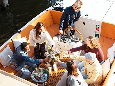 Open boat cruise with drinks people saying cheers having fun