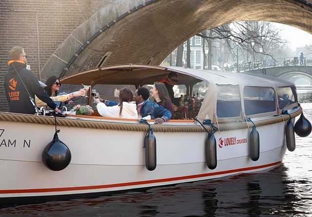 Lovely cruises people going under bridge sun