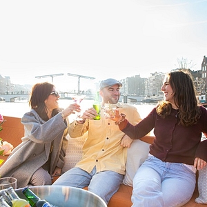 People enjoying drink on open boat lovely cruises view of amstel