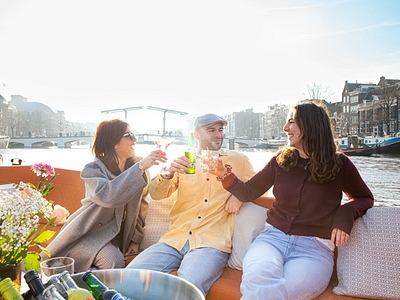 People enjoying drink on open boat lovely cruises view of amstel